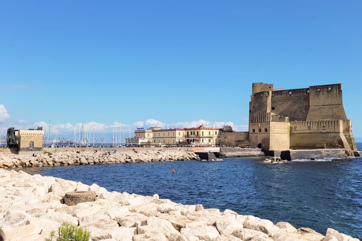 The Castel dell'Ovo on its rocky islet in the Bay of Naples, seen across a breakwater